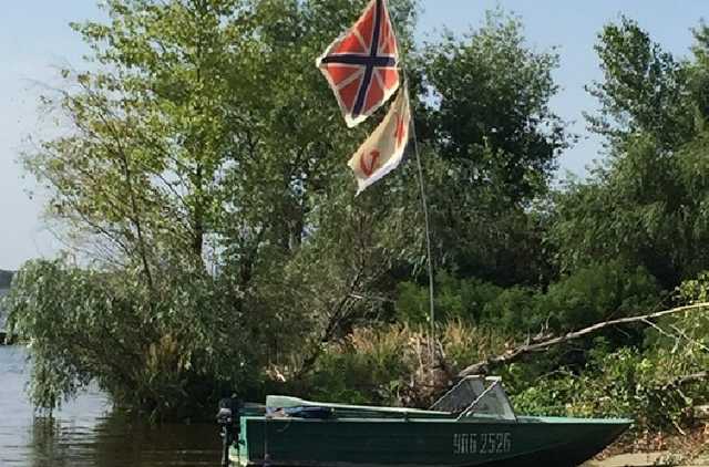 В Кременчуге плавает лодка с российским и советским флагами