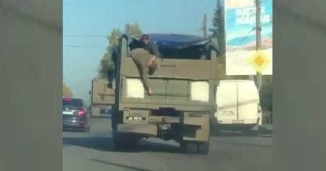 Два захватчика сражаются в кузове грузовика, двигающегося по улице оккупированного Херсона