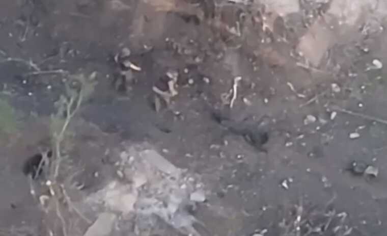 Два окупанти тягнуть третього, прив’язавши йому до ніг мотузку