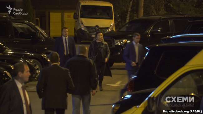 Охоронець веде жінку до автівки, зареєстровану на ГПУ dqxikeidqxidqeant