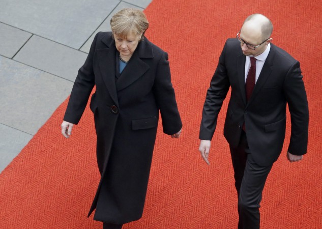 German Chancellor Angela Merkel, left, and the Prime Minister of Ukraine Arseniy Yatsenyuk, right, walk on the red carpet during a military welcome ceremony at the chancellery in Berlin, Germany, Thursday, Jan. 8, 2015. (AP Photo/Michael Sohn) dqxikeidqxidqrant