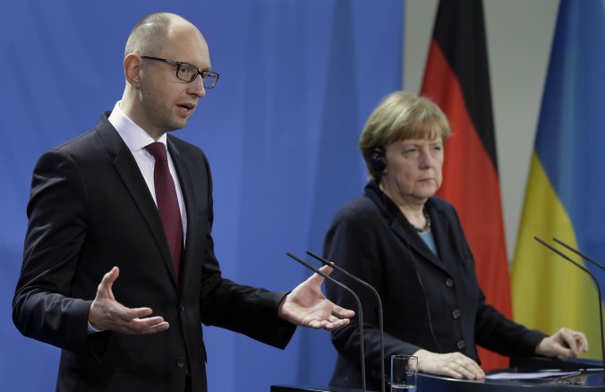 German Chancellor Angela Merkel, right, and the Prime Minister of Ukraine Arseniy Yatsenyuk, left, address the media during a joint press conference as part of a meeting at the chancellery in Berlin, Germany, Thursday, Jan. 8, 2015. (AP Photo/Michael Sohn)