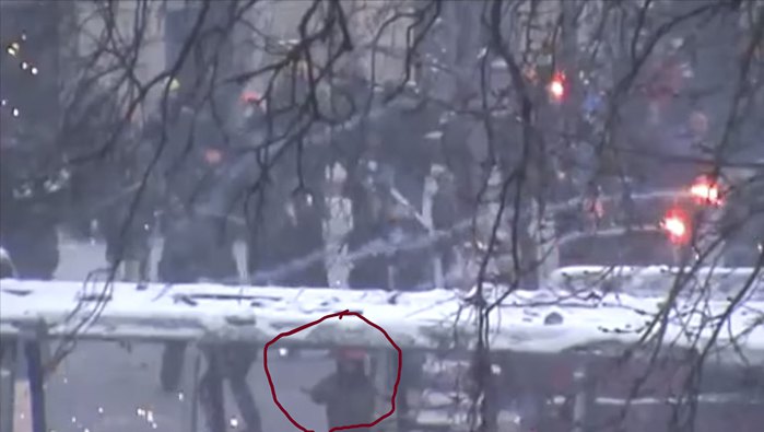 Жизневський стоїть між вікнами згорілого автобуса