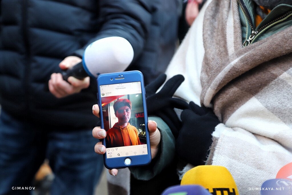 Девушка показывает фото своего пропавшего брата