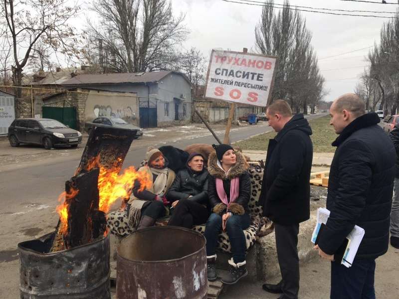 A group of people standing around a fireDescription automatically generated