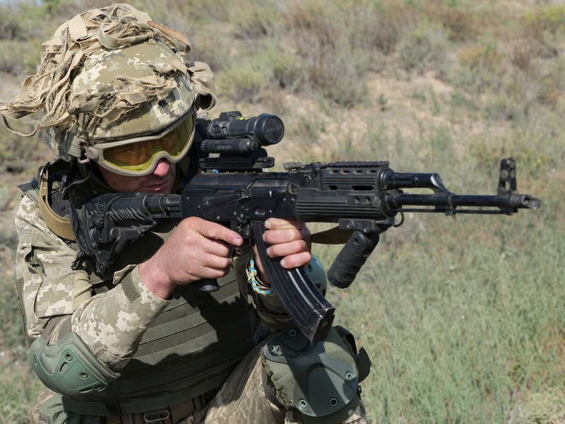 Воин ВСУ стреляет из автомата во время учений.