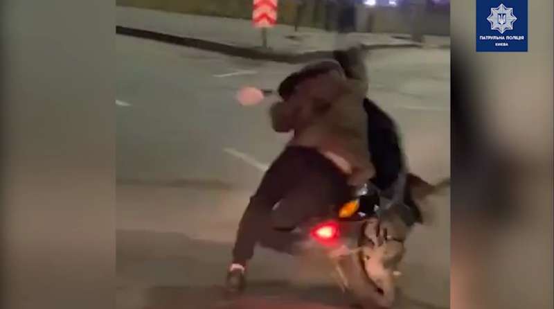 Мужчина пытается удержать мопед