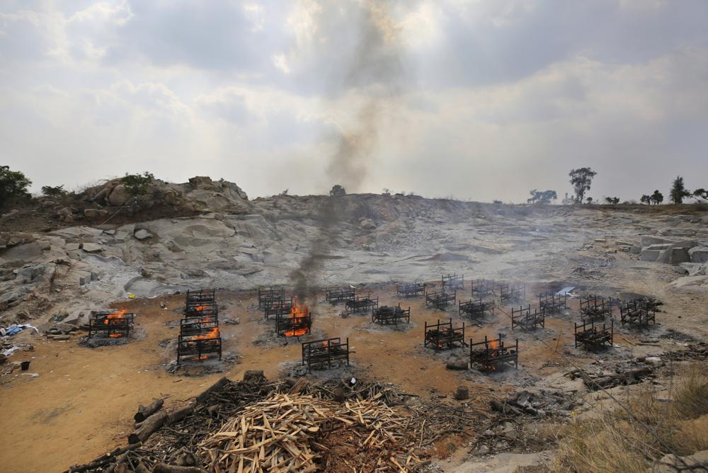 FILE - In this May 5, 2021, file photo, funeral pyres of twenty-five COVID-19 victims burn at an open crematorium set up at a granite quarry on the outskirts of Bengaluru, India. India’s excess deaths during the pandemic could be a staggering 10 times the official COVID-19 toll, likely making it modern India’s worst human tragedy, according to the most comprehensive research yet on the ravages of the virus in the south Asian country. (AP Photo/Aijaz Rahi, File)