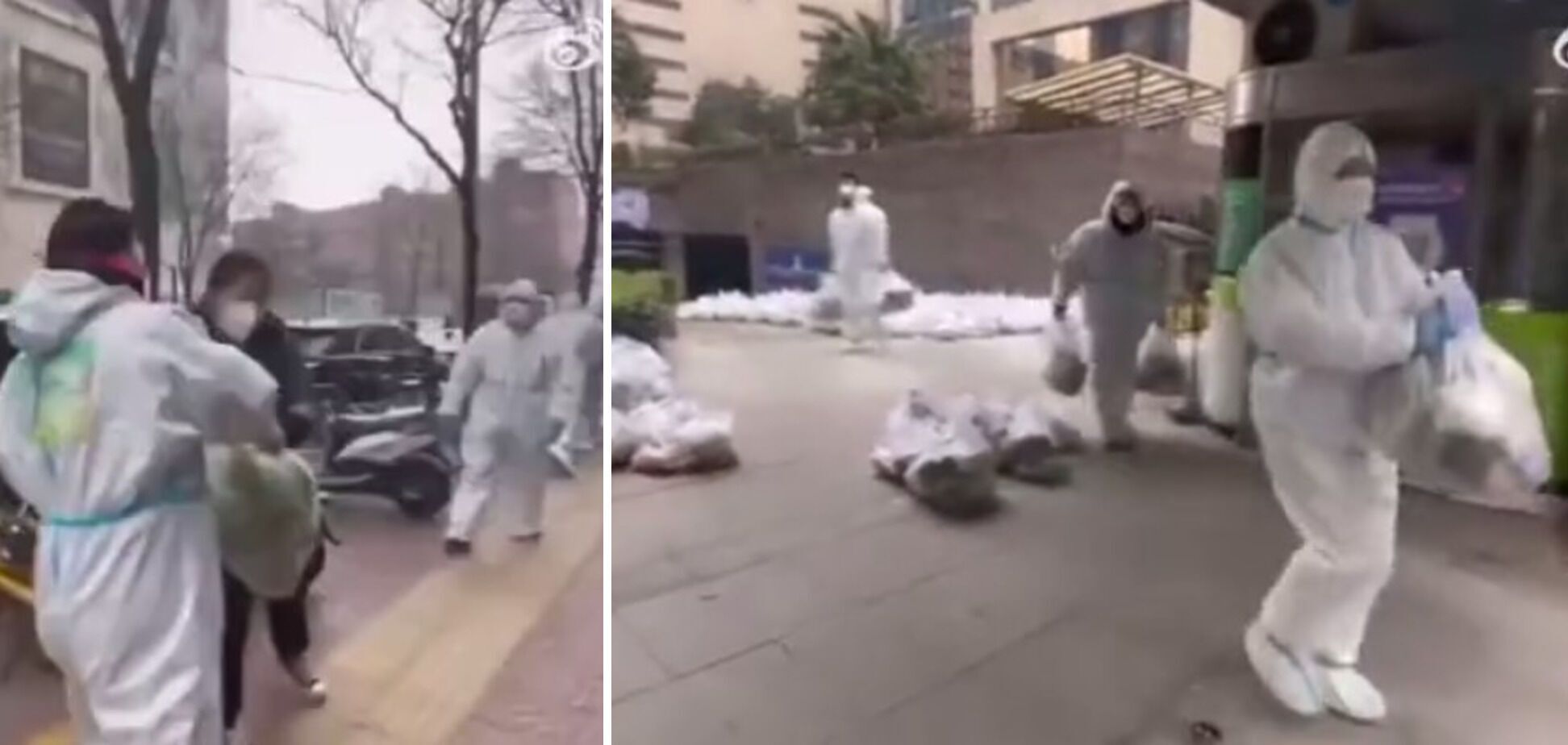 Рабочие в защитных костюмах переносят пакеты с едой для людей в карантинных лагерях