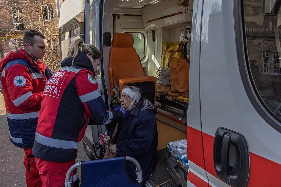 Медики оказывают помощь пострадавшей в результате обстрела