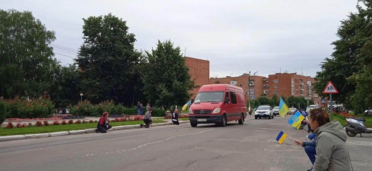 Кортеж зустрічали, стоячи на колінах.