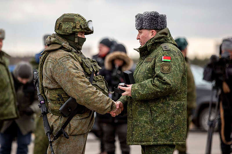 На снимке, опубликованном Минобороны России, российских военнослужащих поздравляет министр обороны Беларуси Виктор Хренин, 20 февраля 2022 года. Их награждали часами после завершения заключительного этапа российско-белорусских учений «Союзная решимость-2022» на Обуз-Лесновском полигоне. После окончания военных учений Хренин заявил, что Беларусь и Россия решили продолжить совместную проверку сил реагирования. По его словам, такое решение приняли Александр Лукашенко и президент России Владимир Путин «в связи с нарастанием военной активности у внешних границ Союзного государства и обострением ситуации на Донбассе». Фото: Reuters