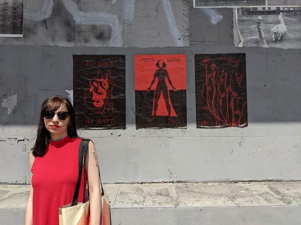 Дина Чмуж на фоне своих работ