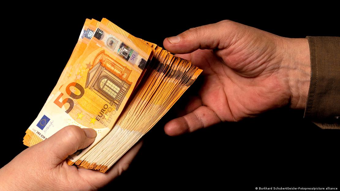 Одна рука дає іншій пачку з купюрами у 50 євро (символічне фото) Одна рука дає іншій пачку з купюрами у 50 євро (символічне фото)