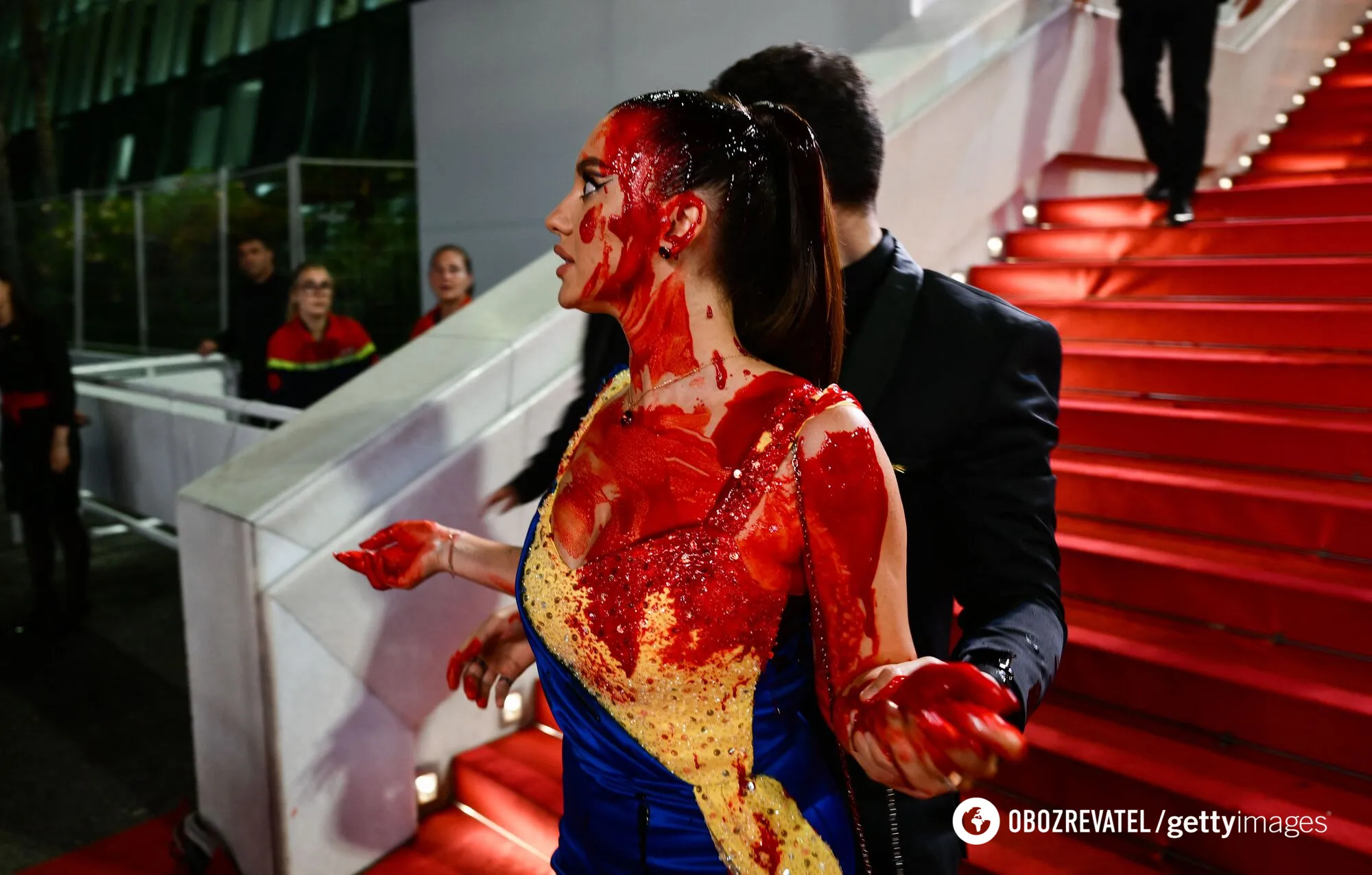 У Каннах грубо обійшлися з проукраїнською демонстранткою, яка облила себе штучною кровʼю. Фото dqxikeidqxidqeant