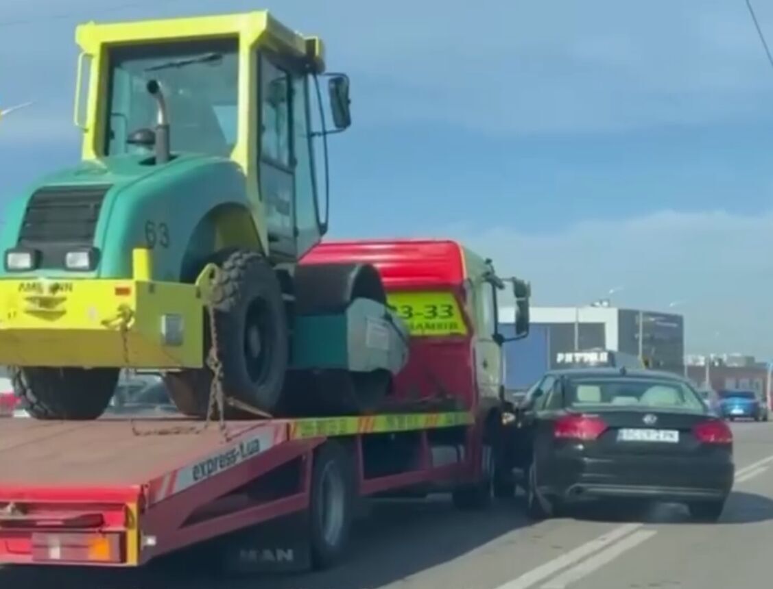 В Киеве произошла авария с участием легковушки и эвакуатора, который перевозил каток: возникла пробка. Видео