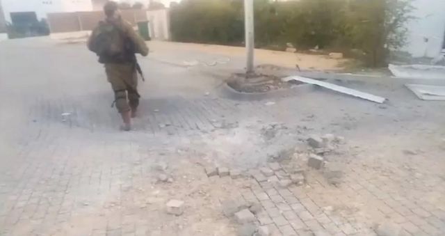 Кибуц Нир-Ам всего в 2 км от сектора Газа, но ему удалось отразиться. На фото – израильский военный заходит в поселение вечером дня нападения