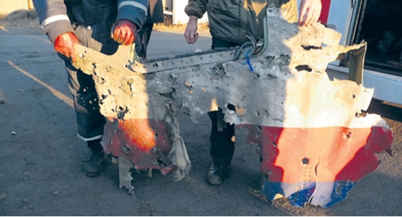 An armed pro-Russian separatist stands on part of the wreckage of the Malaysia Airlines Boeing 777 plane after it crashed near the settlement of Grabovo in the Donetsk region, July 17, 2014. The Malaysian airliner flight MH17 was brought down over eastern Ukraine on Thursday, killing all 295 people aboard and sharply raising stakes in a conflict between Kiev and pro-Moscow rebels in which Russia and the West back opposing sides. REUTERS/Maxim Zmeyev (UKRAINE - Tags: TRANSPORT DISASTER POLITICS CIVIL UNREST TPX IMAGES OF THE DAY) - RTR3Z3JK