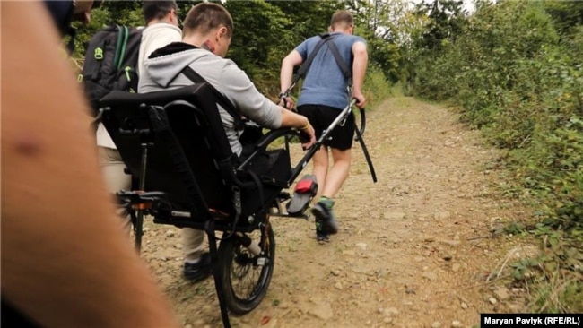 Волонтеры поднимают в горы воина с ампутацией конечностей на «джульетке»